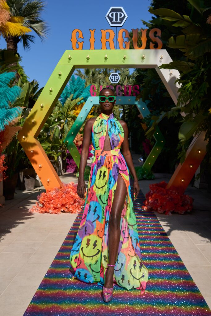 A fitted multicolor silk sleeveless dress with a high neckline and asymmetric slit detail.