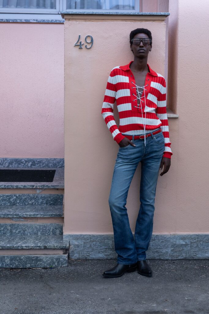 A fitted long-sleeve striped shirt paired with straight-leg jeans.