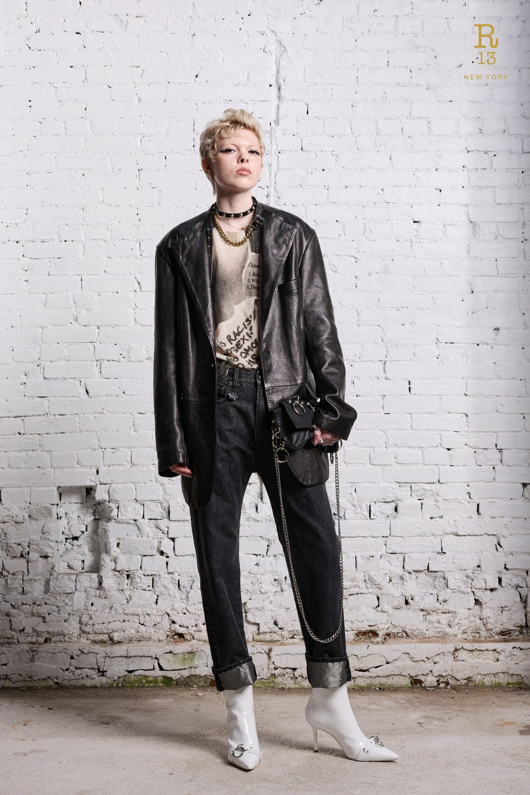 A relaxed black leather jacket paired with straight-leg denim pants and a white top.
