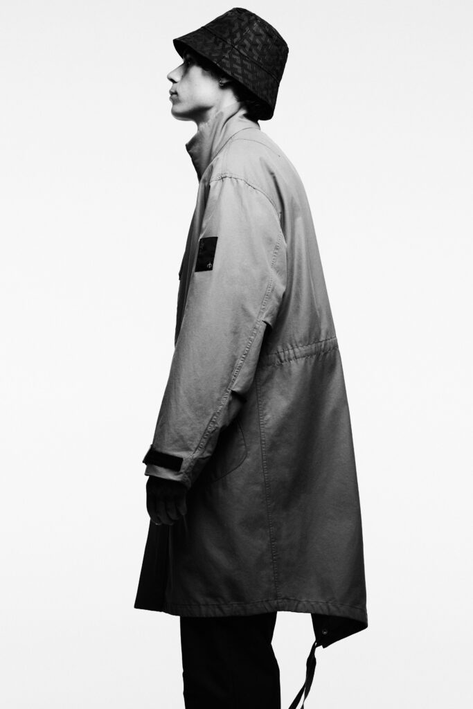 A relaxed beige long-sleeve coat with a collared design and asymmetric hem.