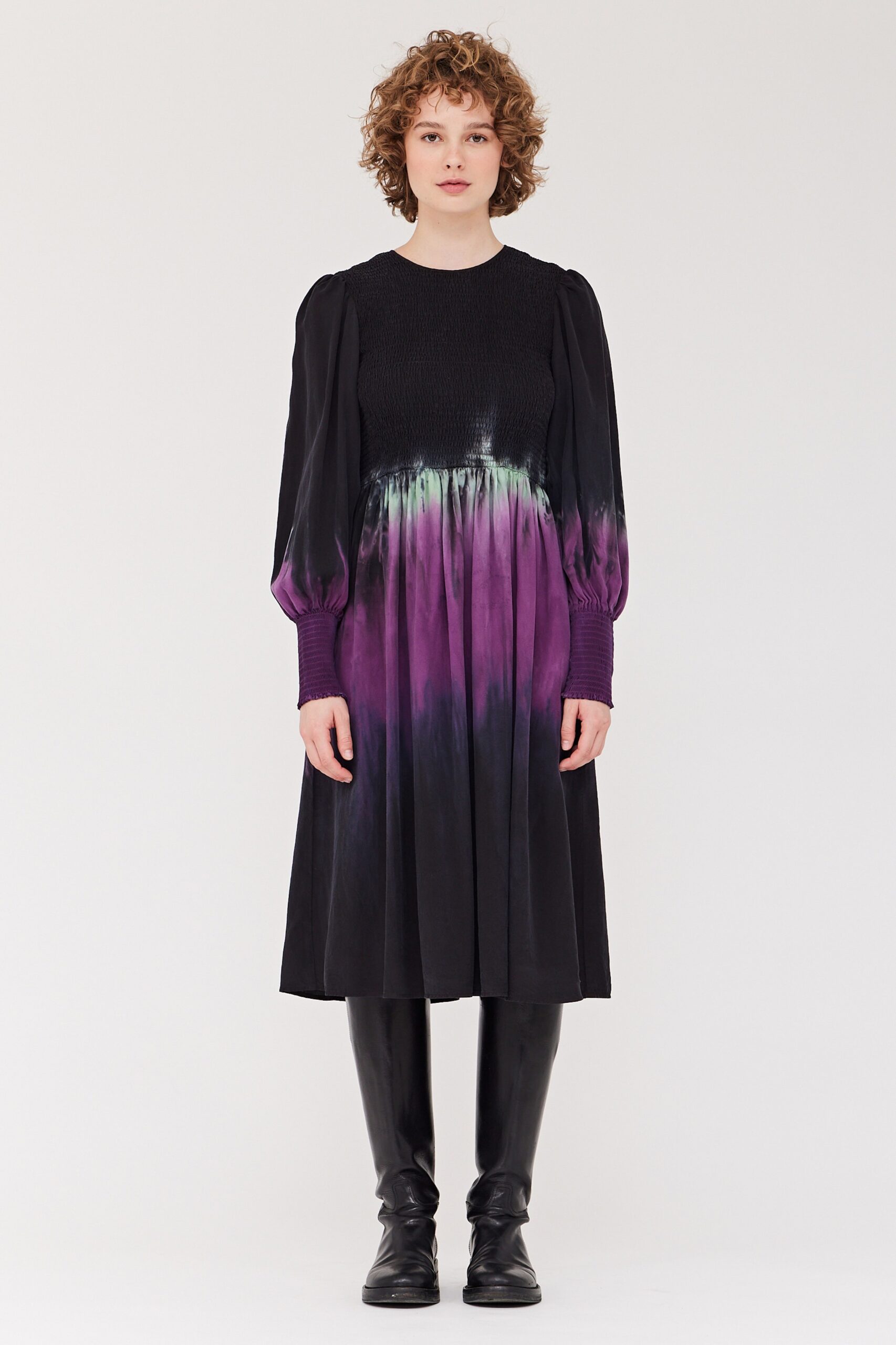 A relaxed black and purple dress with long sleeves and a pleated design.