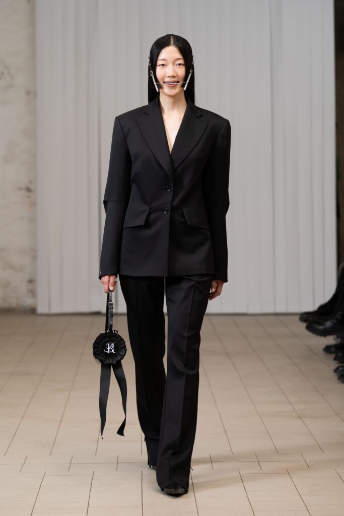A tailored black blazer with long sleeves paired with matching black pants for a chic look.