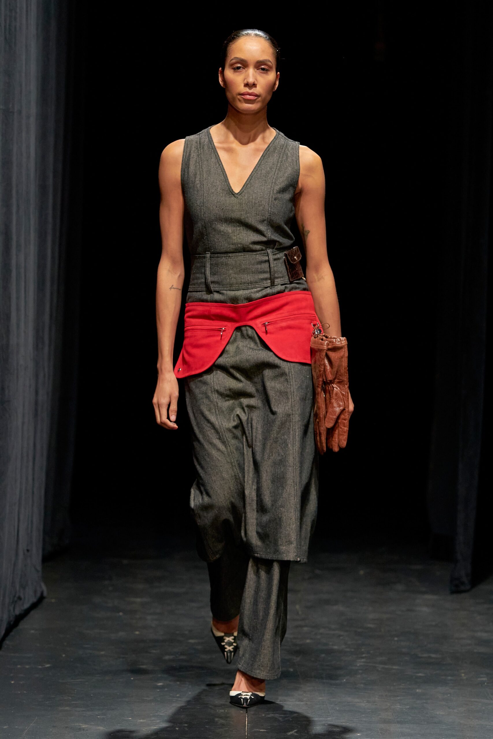 A fitted gray sleeveless dress with a V-neckline and asymmetric design detail.