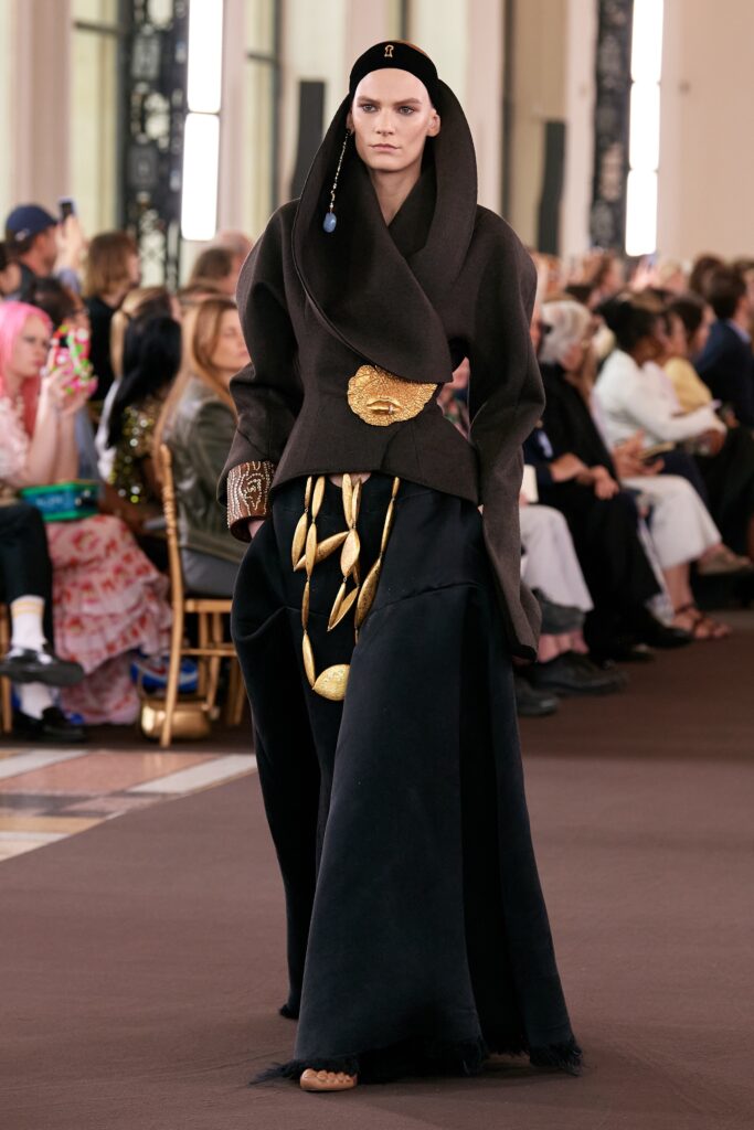 A relaxed black wool long-sleeve dress with a high-neck and asymmetric design detail.