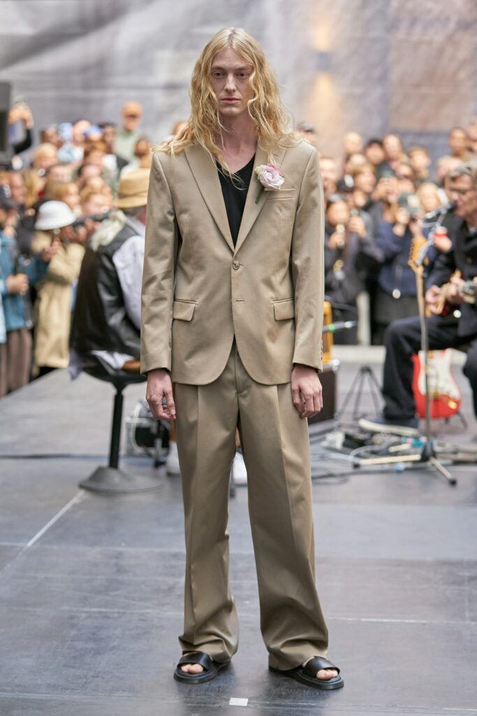 A relaxed beige suit with a collared long-sleeve shirt and straight-leg trousers.