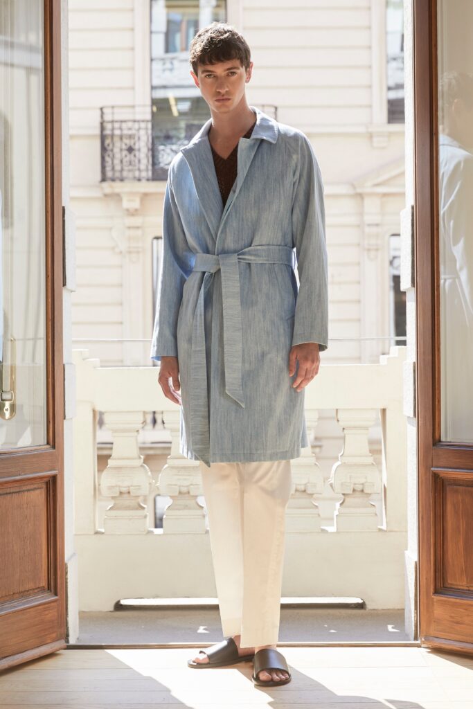 A relaxed blue denim coat with long sleeves and a belted design.