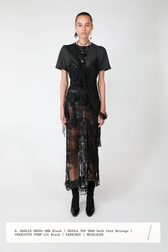 A fitted black layered dress with a short-sleeve top and v-neckline, featuring sheer details.