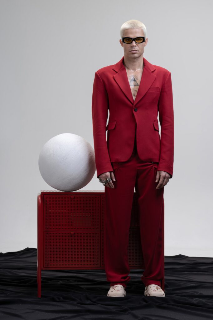 A tailored red suit with long sleeves and a collared design, featuring buttoned details.
