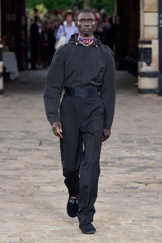A fitted black cotton jumpsuit with long sleeves and a zippered front.