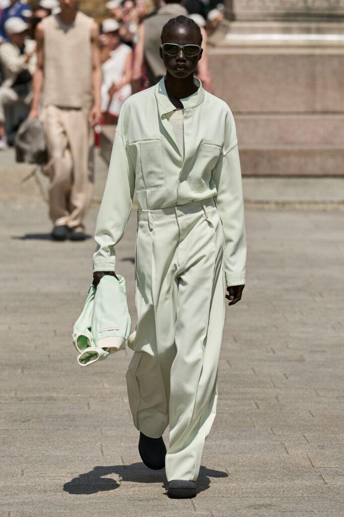 A relaxed green cotton jacket with long sleeves and collared design paired with straight-leg pants.