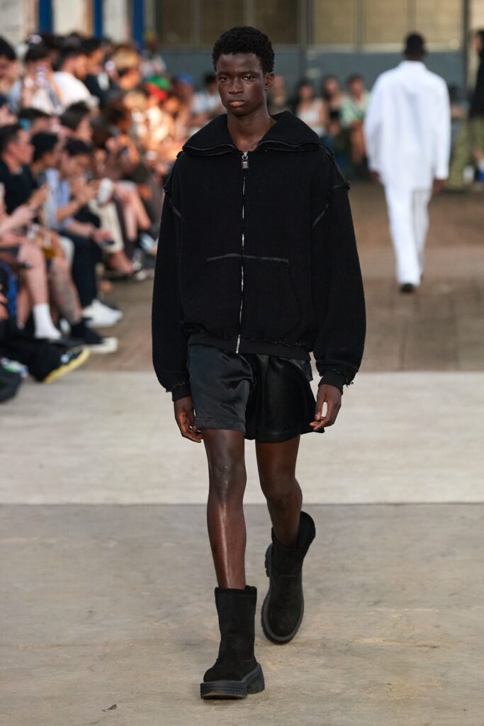 A relaxed black hooded jacket paired with matching shorts, featuring a zippered design.