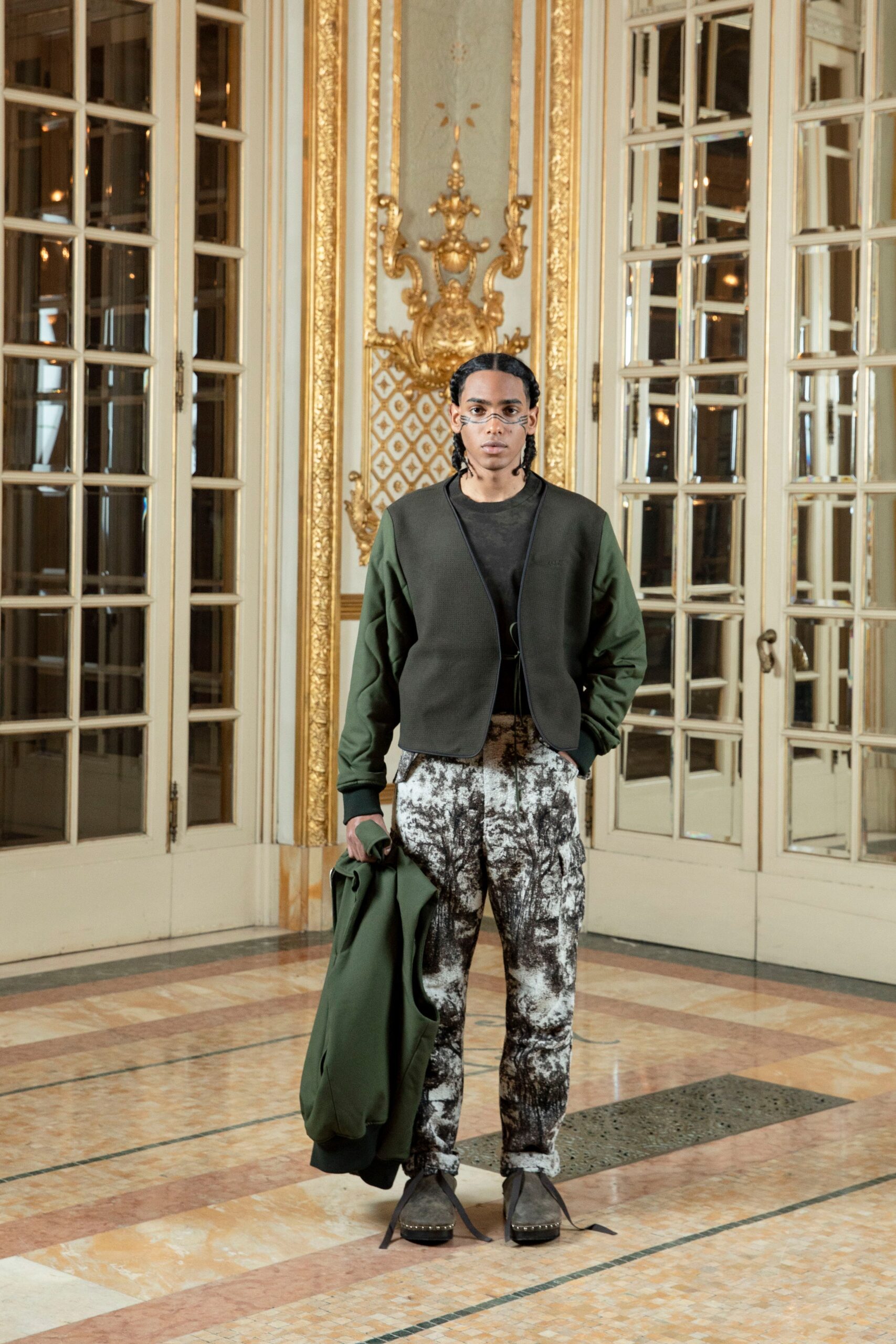 A relaxed green cotton jacket paired with printed black and white pants.
