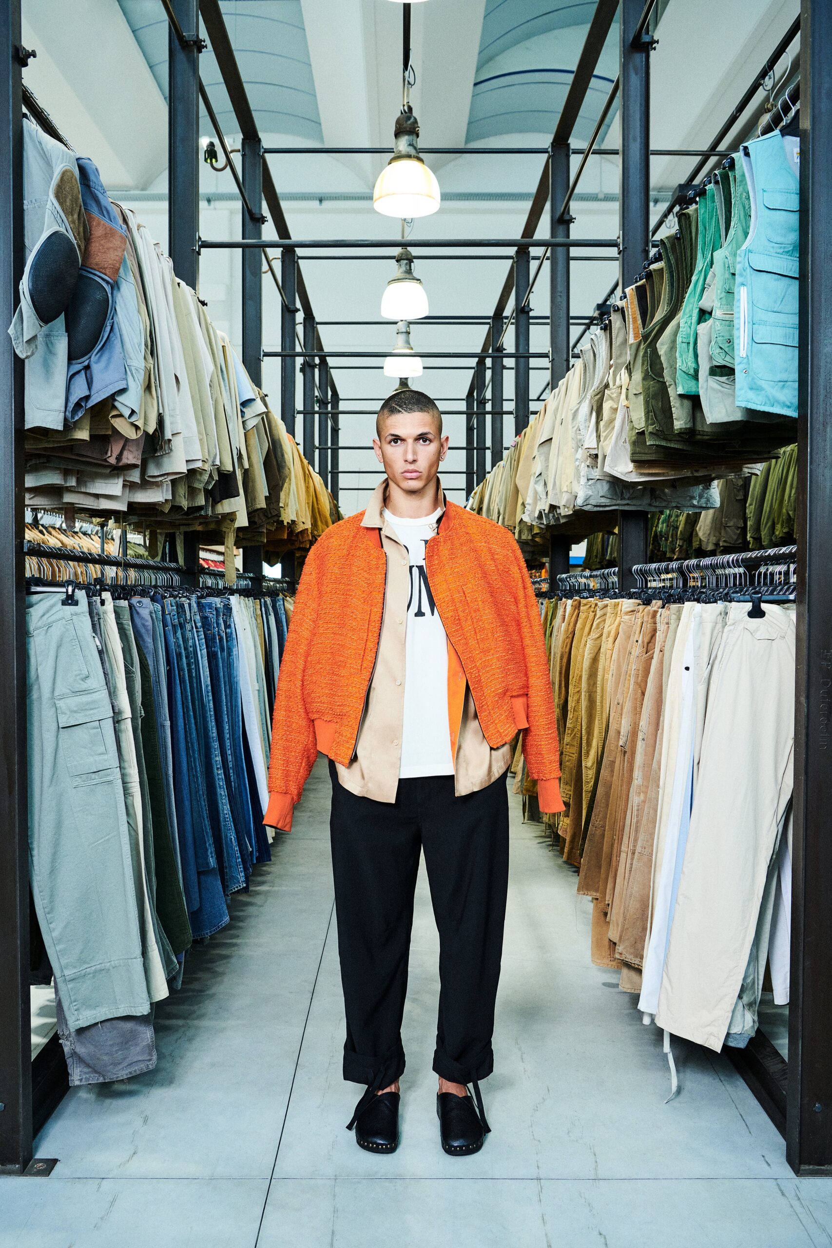 A relaxed-fit orange cotton jacket layered over a collared beige shirt with button details.