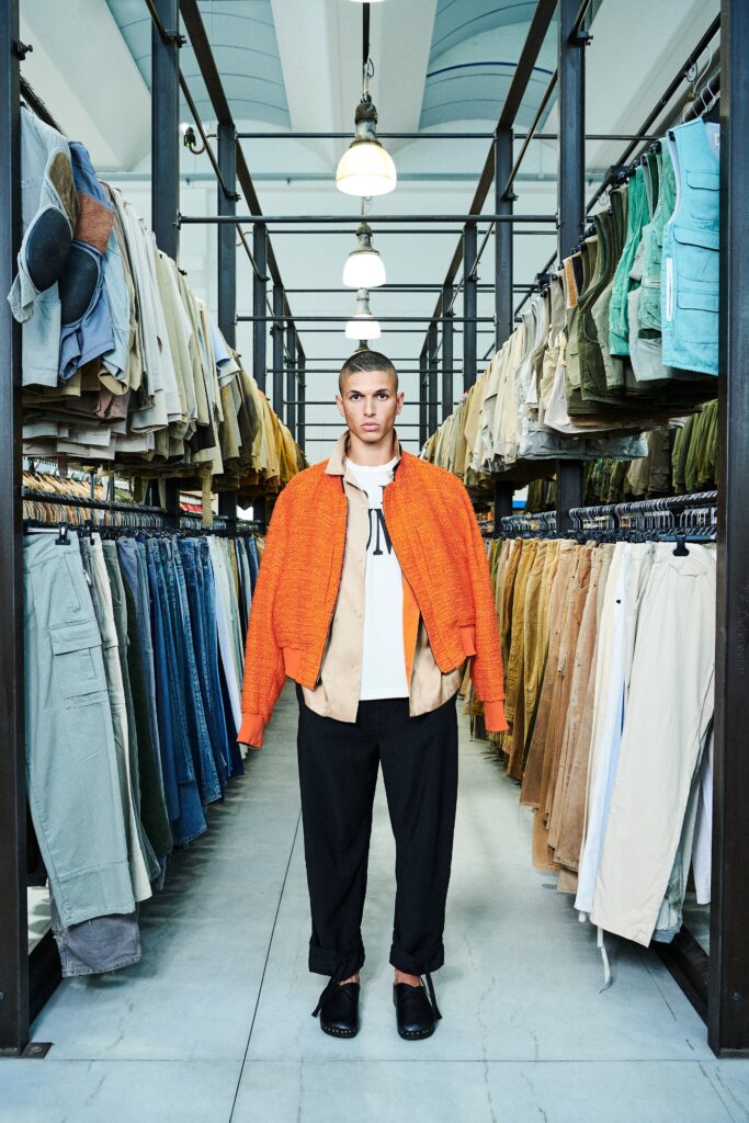A relaxed orange cotton jacket with a collared neckline paired with black pants.