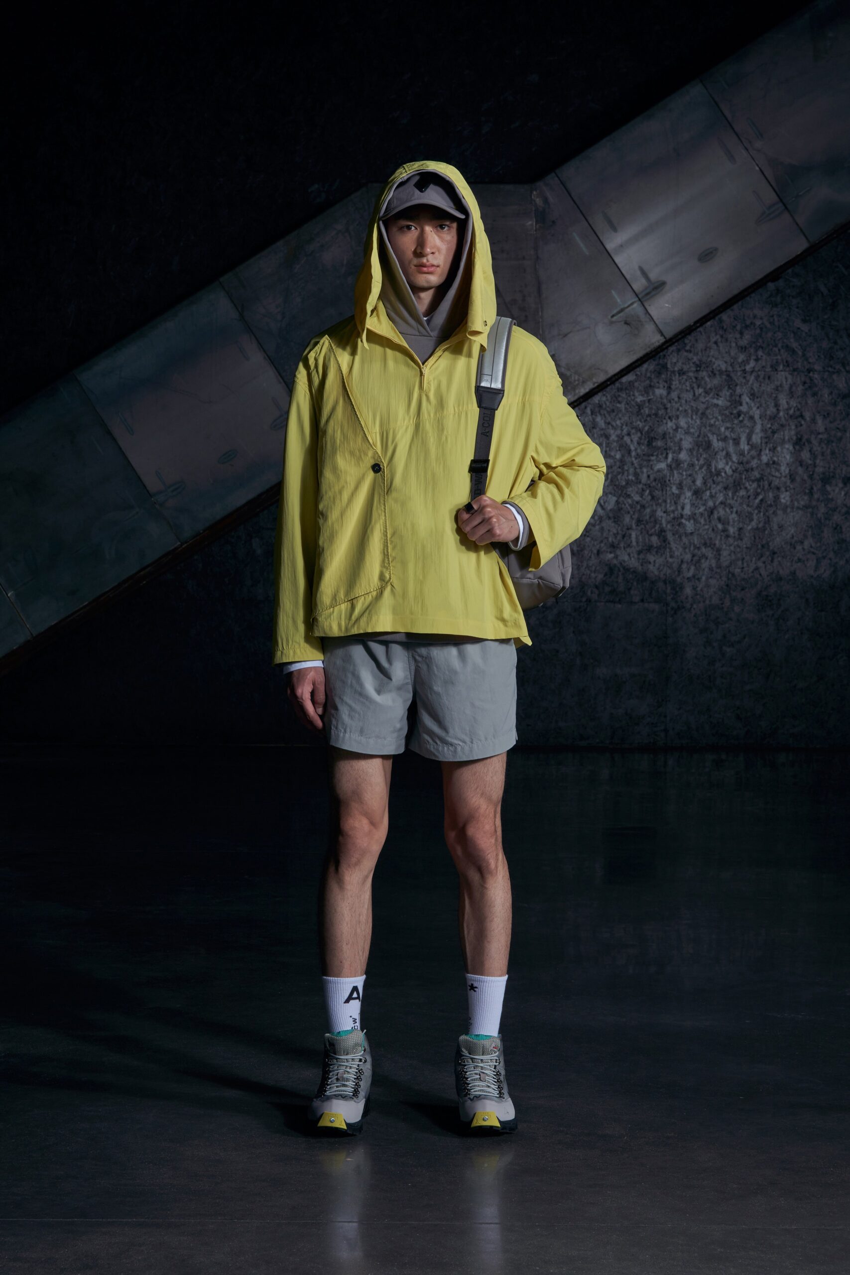 A relaxed yellow hooded jacket paired with gray shorts, perfect for a casual look.