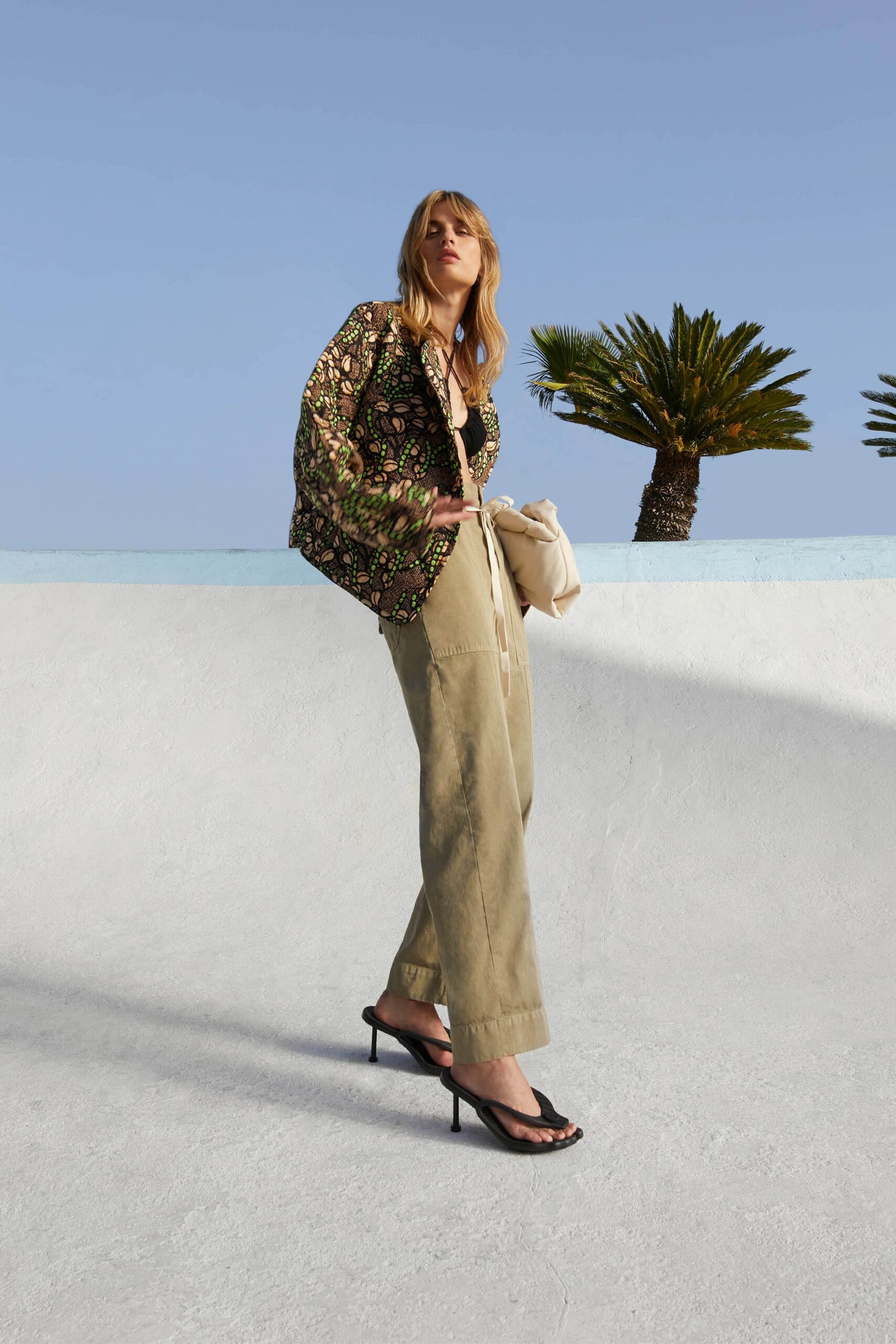 printed black silk blouse with beige pants