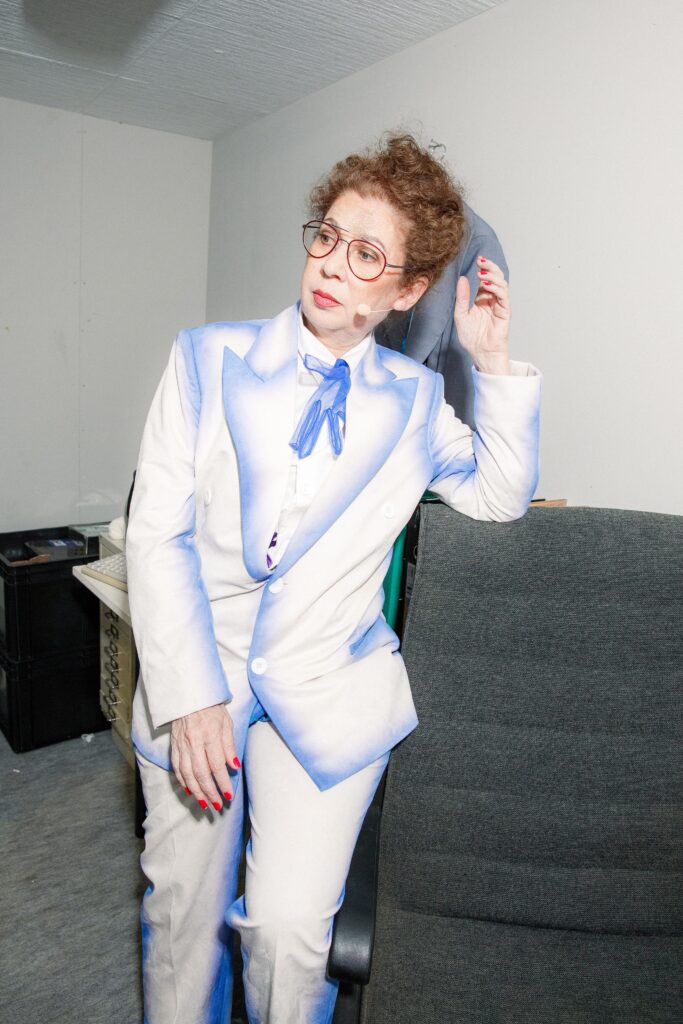 A tailored white and blue suit with long sleeves and a collared design, featuring a color-blocked detail.