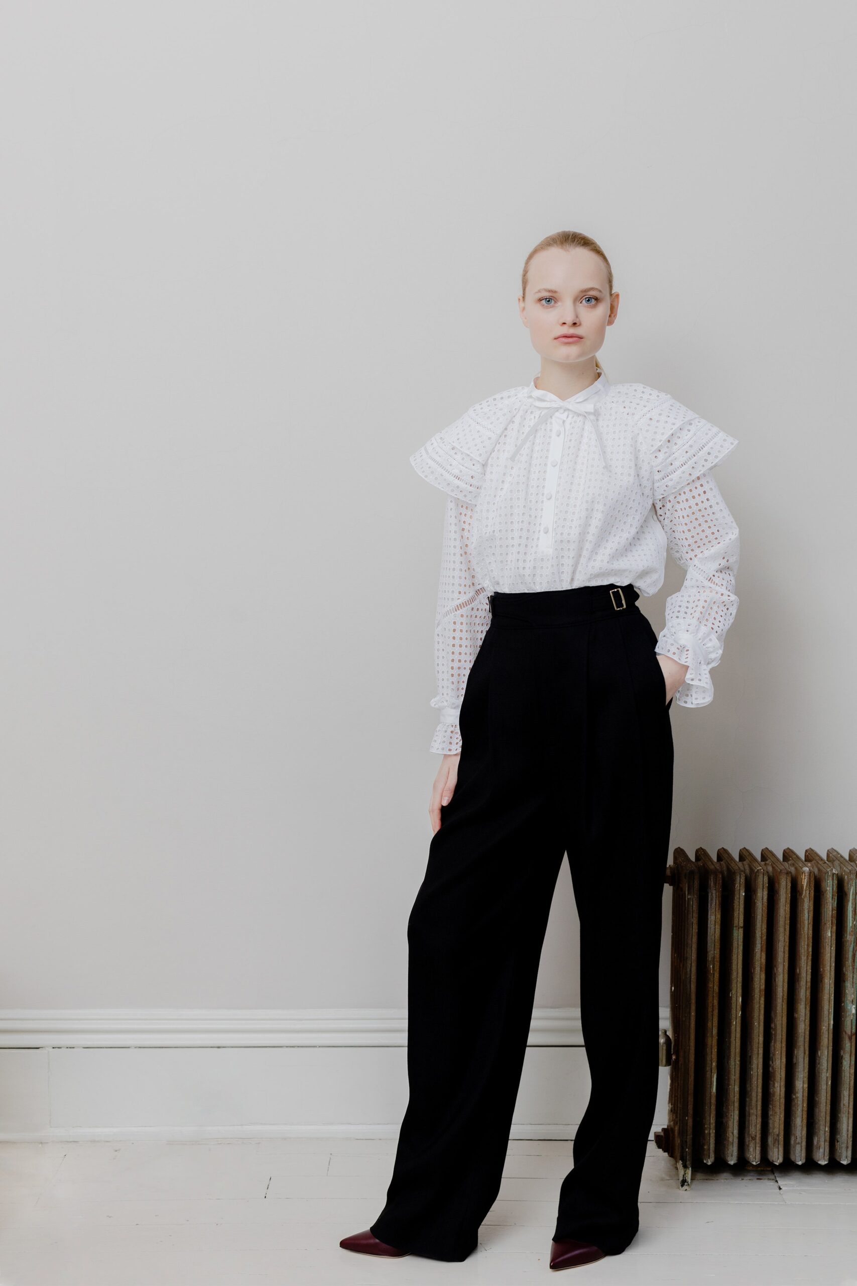 white ruffled shirt and black tailored pants
