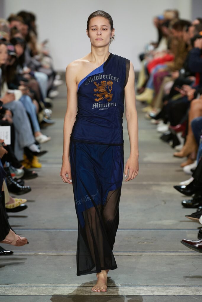 A relaxed blue sheer sleeveless dress with a high neckline and asymmetric design.