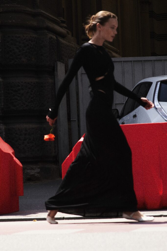 A fitted black maxi dress with long sleeves and a V-neckline, perfect for elegant occasions.
