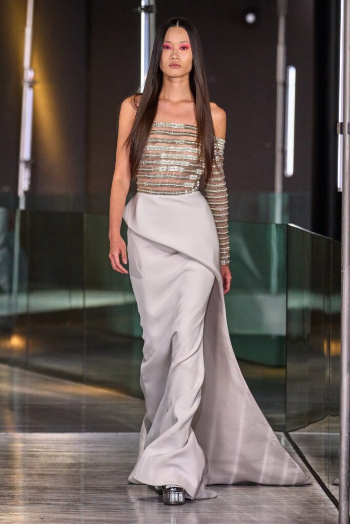 A fitted gray silk gown with a sleeveless design and asymmetric detailing.