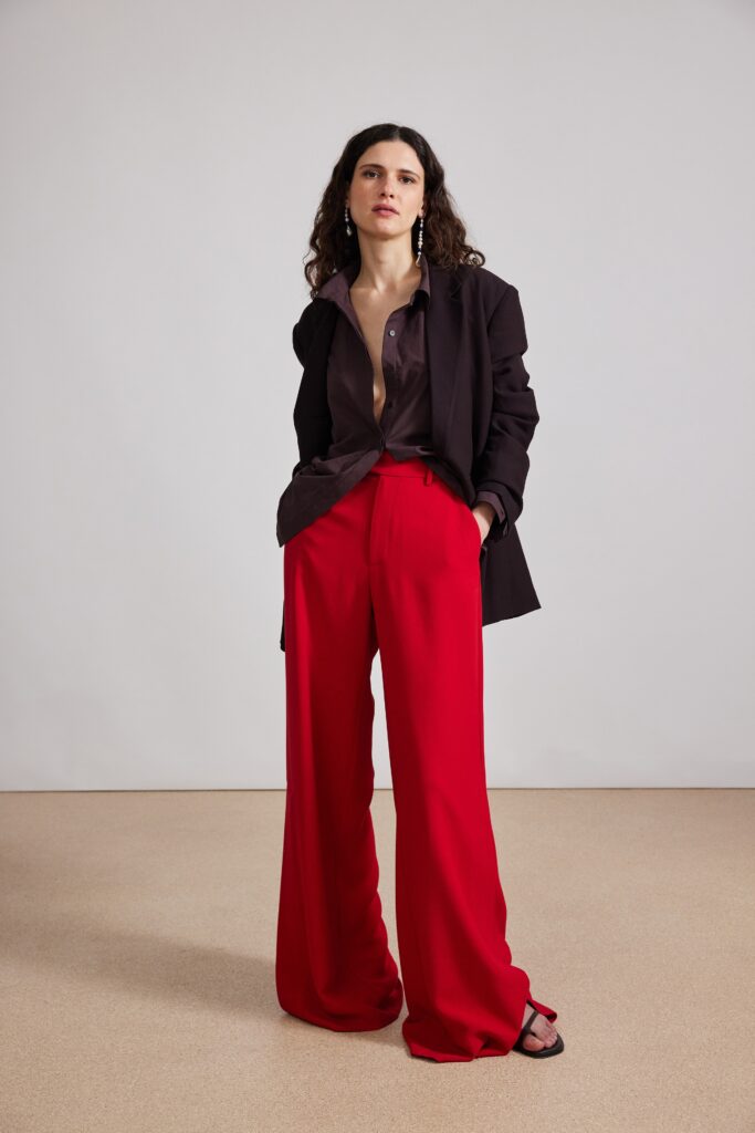 A relaxed black blazer paired with wide-leg red pants for a stylish look.