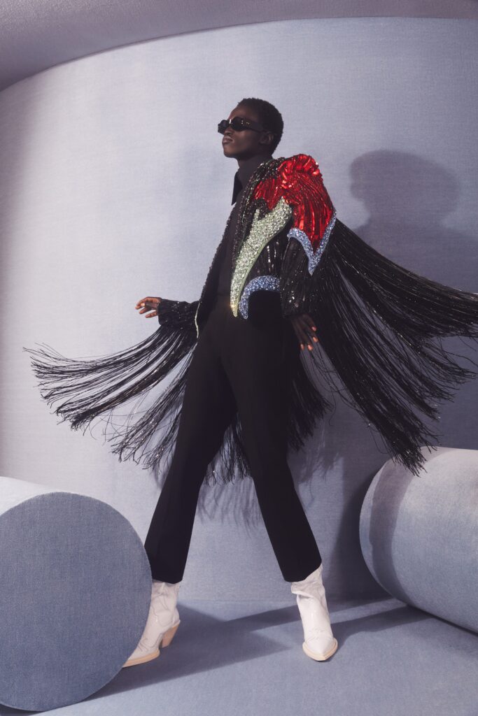 A fitted black jacket with colorful fringes paired with sleek black pants.