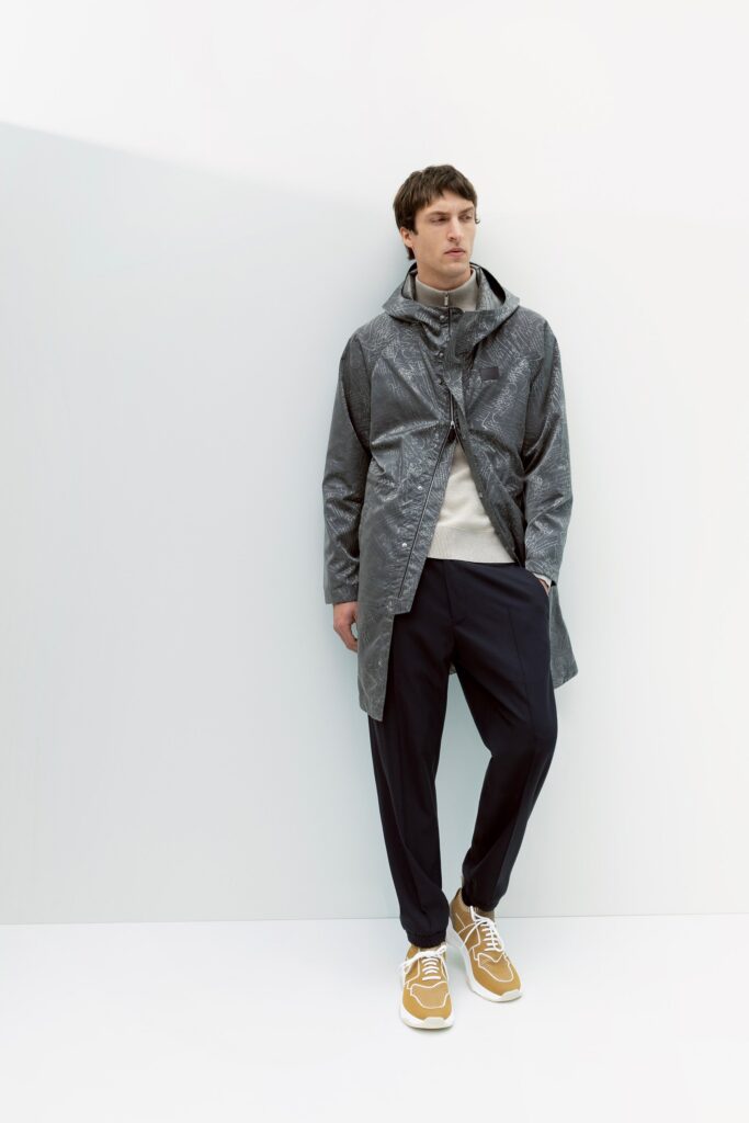 A relaxed gray coat with a collared neckline paired with navy pants.