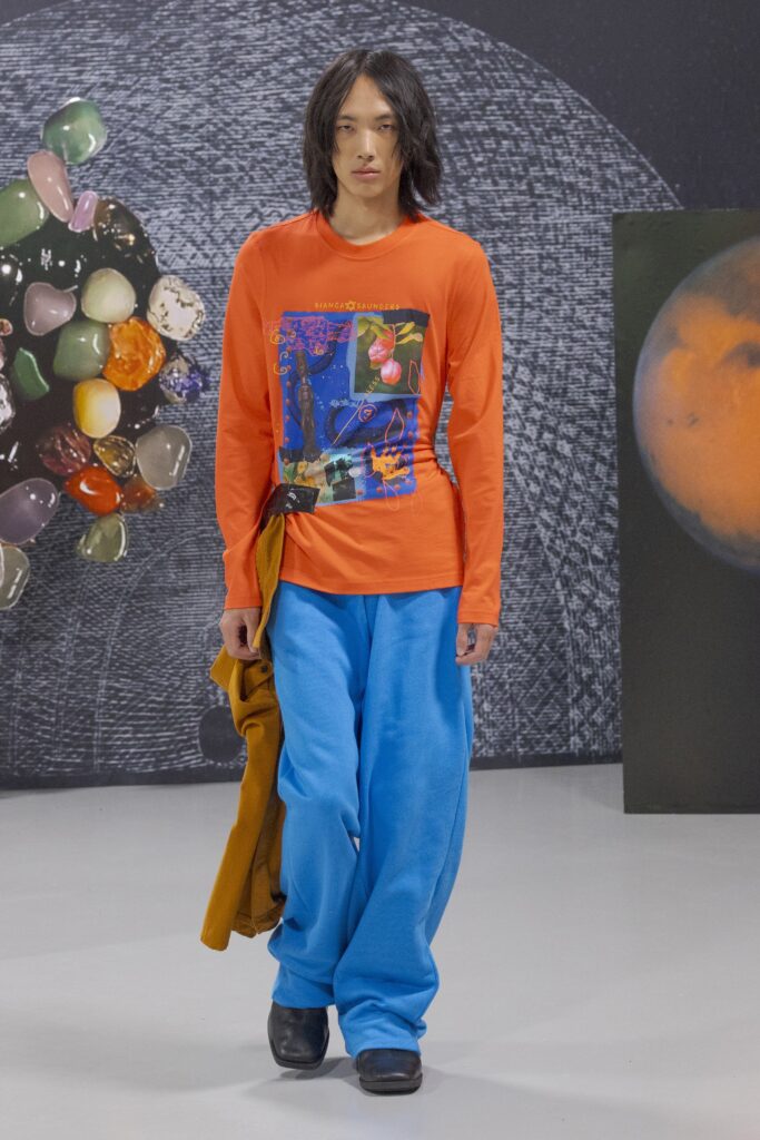 A relaxed long-sleeve orange shirt with a print paired with blue relaxed-fit pants.