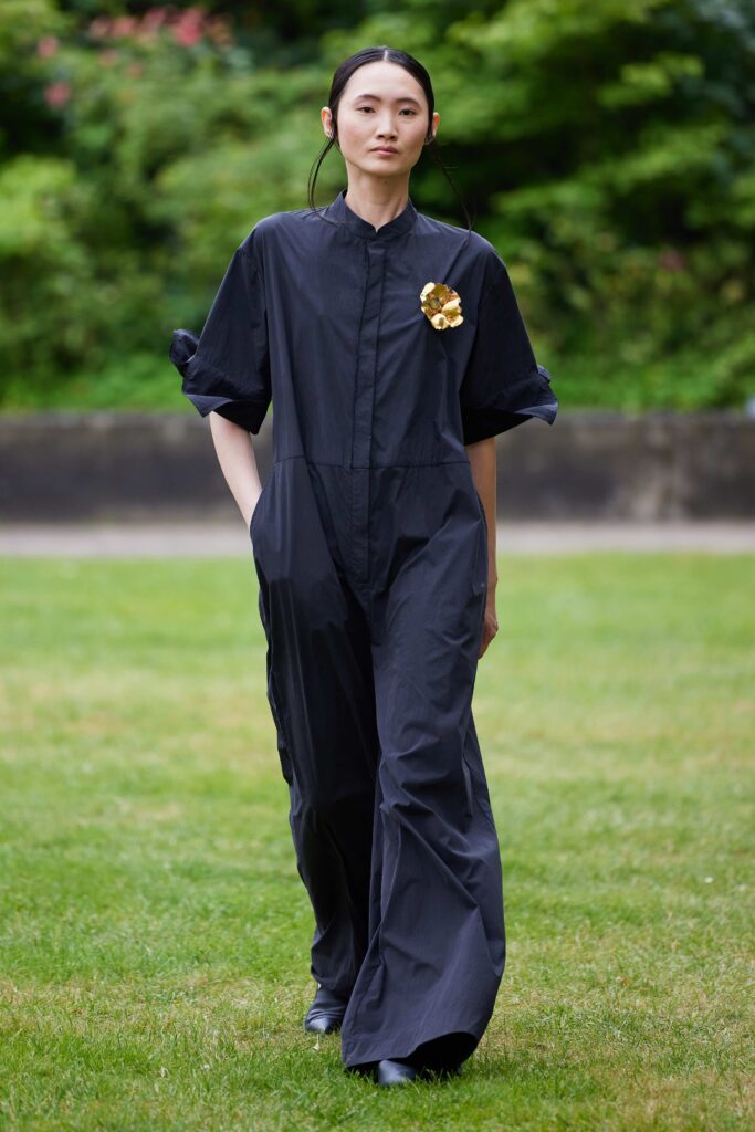 An oversized black cotton jumpsuit with long sleeves and a relaxed fit.