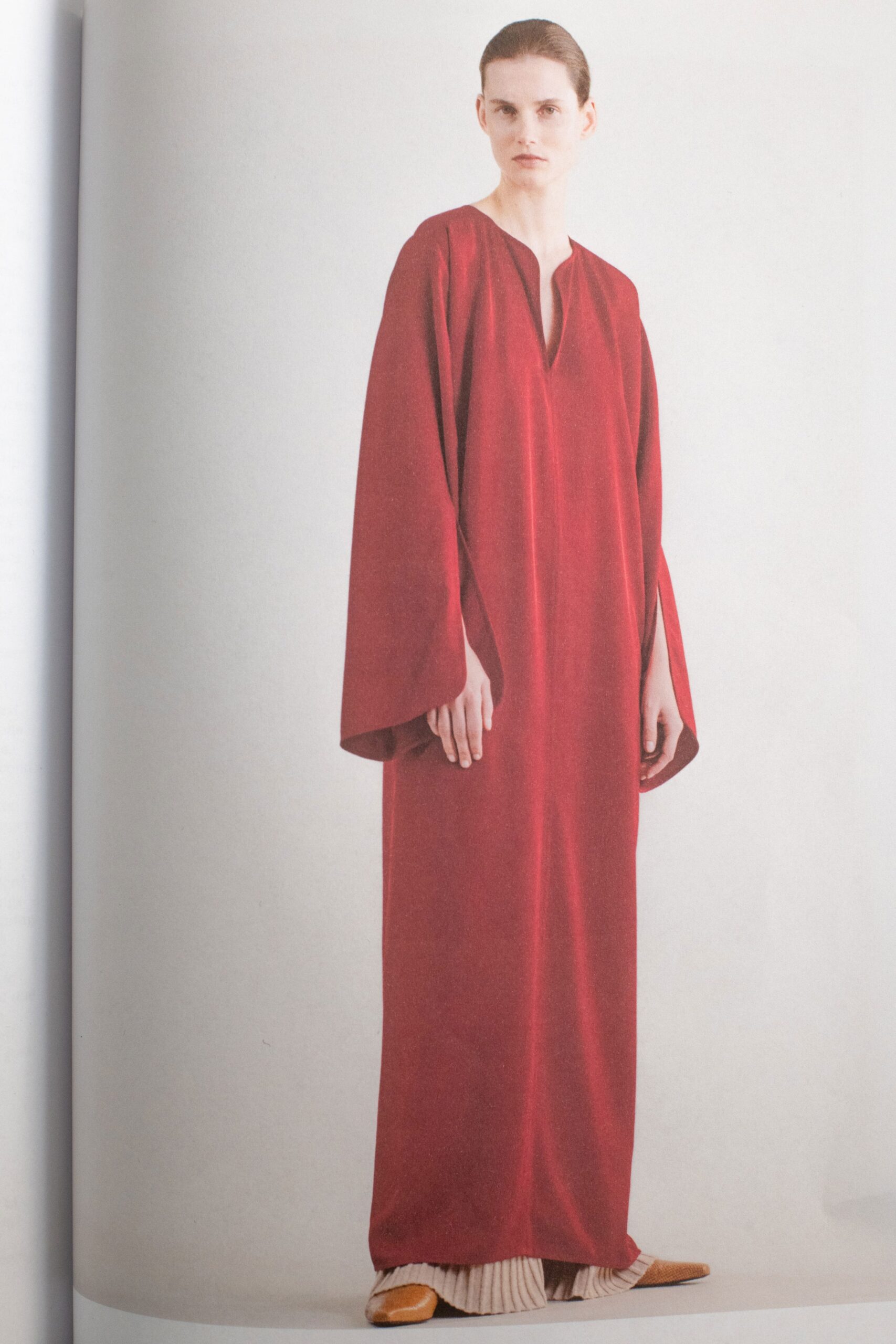 A relaxed red cotton dress with long sleeves and a V-neckline.