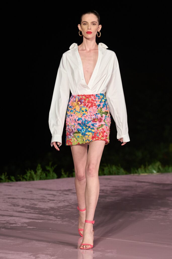 A fitted white long-sleeve shirt paired with a mini floral skirt.