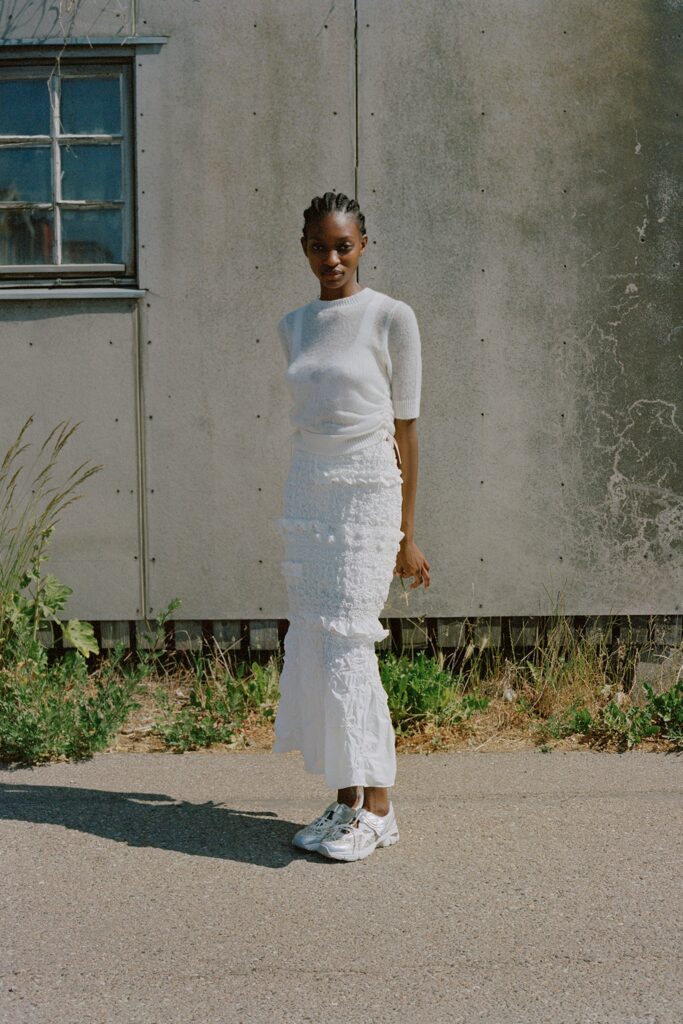 A fitted white top with short sleeves paired with a tiered white skirt.