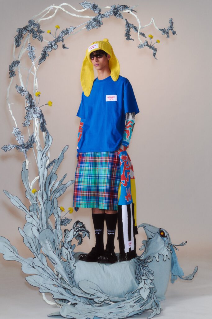 A relaxed blue cotton t-shirt with short sleeves paired with a multicolor checked skirt.