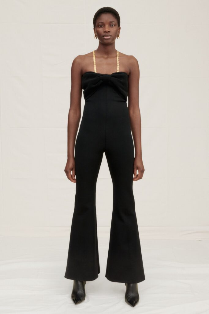 A fitted black sleeveless jumpsuit with a high neckline and flared legs.