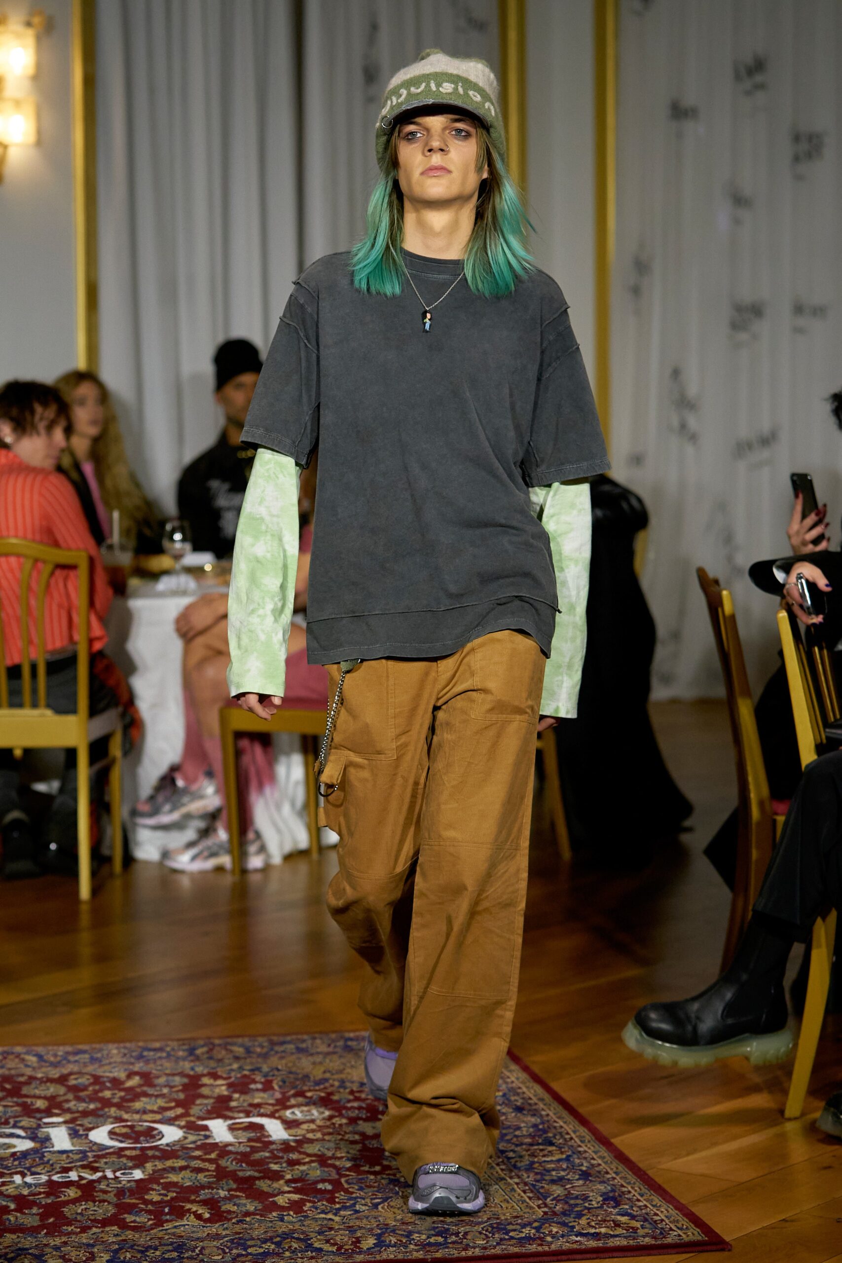 A relaxed gray cotton top with short sleeves paired with brown pants, featuring a layered look.