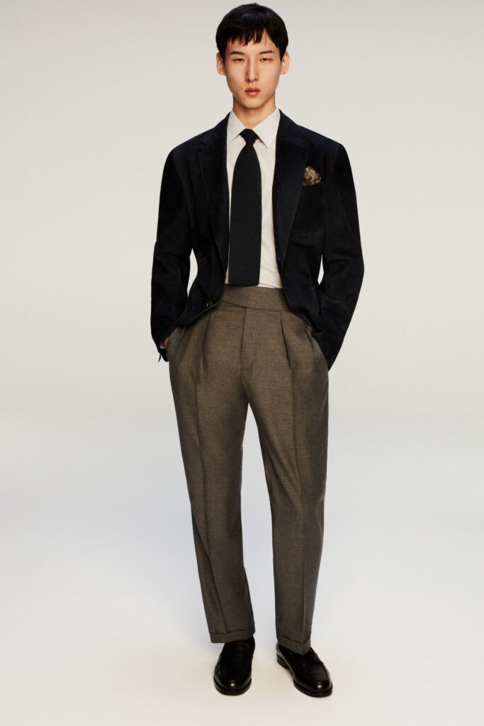 A tailored black velvet blazer paired with gray straight-leg trousers for a sophisticated look.