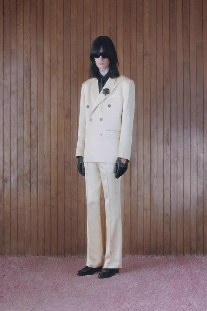A tailored cream silk suit with long sleeves and a buttoned design.
