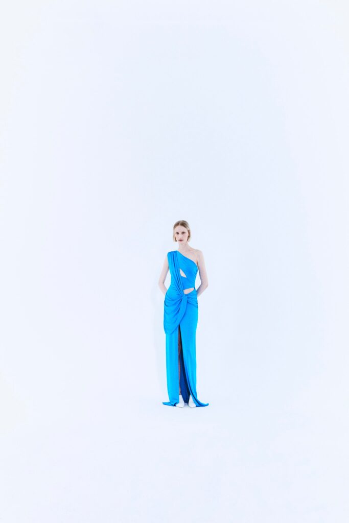 A fitted blue silk dress with a sleeveless design and draped detailing.