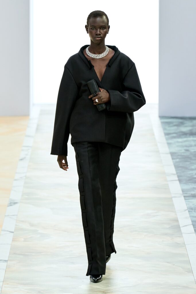 An oversized black jacket with a V-neckline paired with straight-leg black pants.