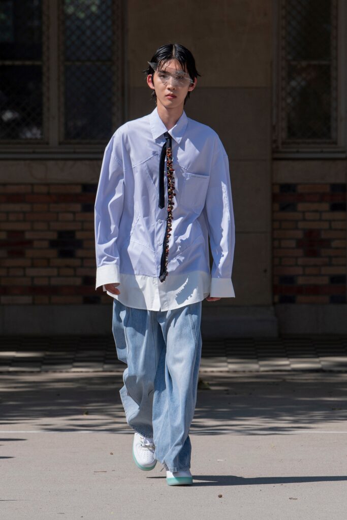 A relaxed blue cotton long-sleeve shirt with a collared design paired with wide-leg pants.
