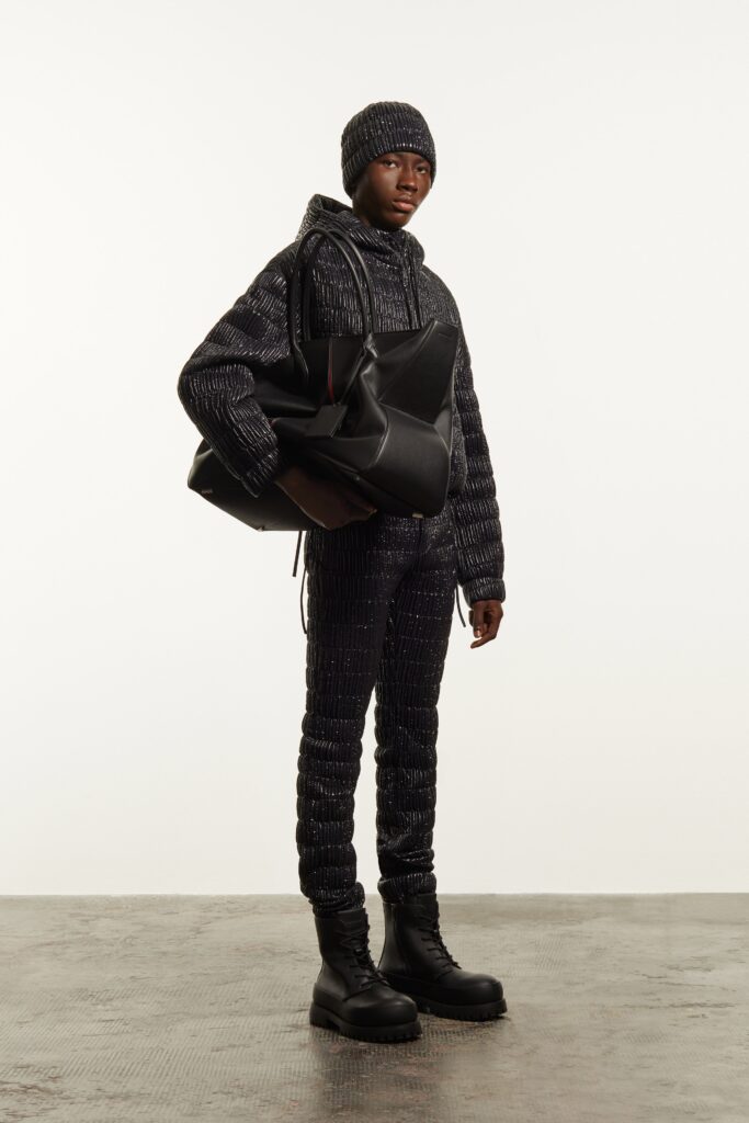 A fitted black jacket with a hood and matching pants, featuring a zippered design.