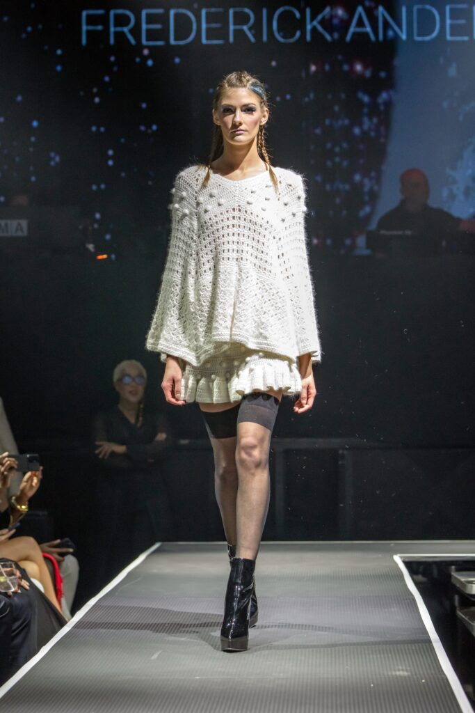 A relaxed white knit dress with a high neckline and layered design.