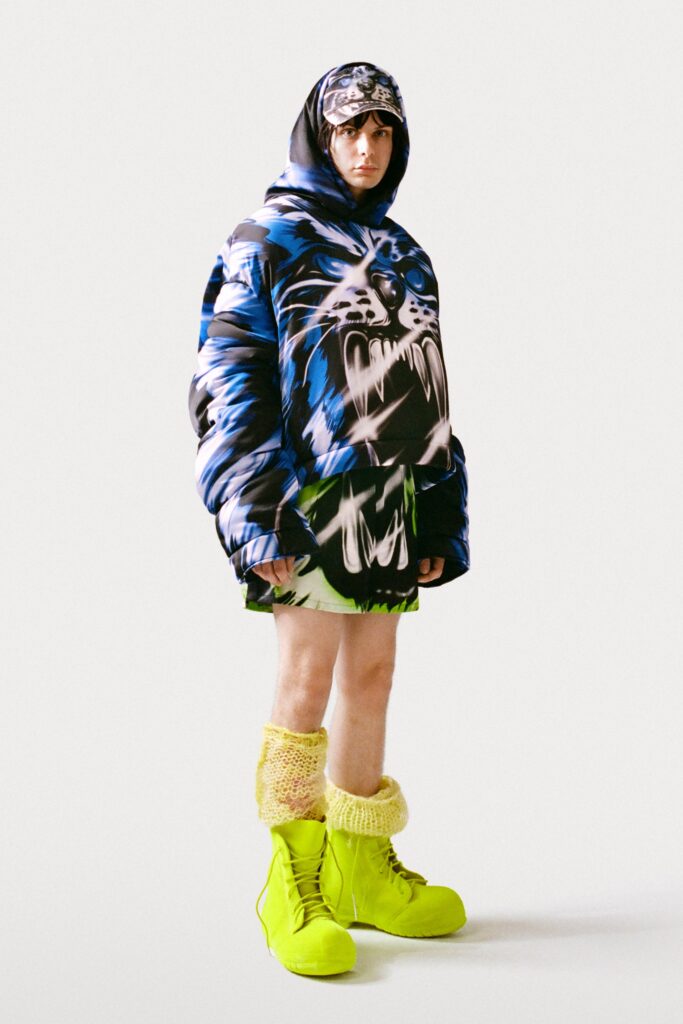 An oversized blue hoodie paired with vibrant green shorts and bold yellow boots.
