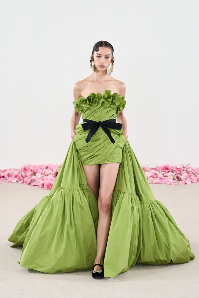 A fitted green strapless dress with ruffled details and a tiered silhouette.