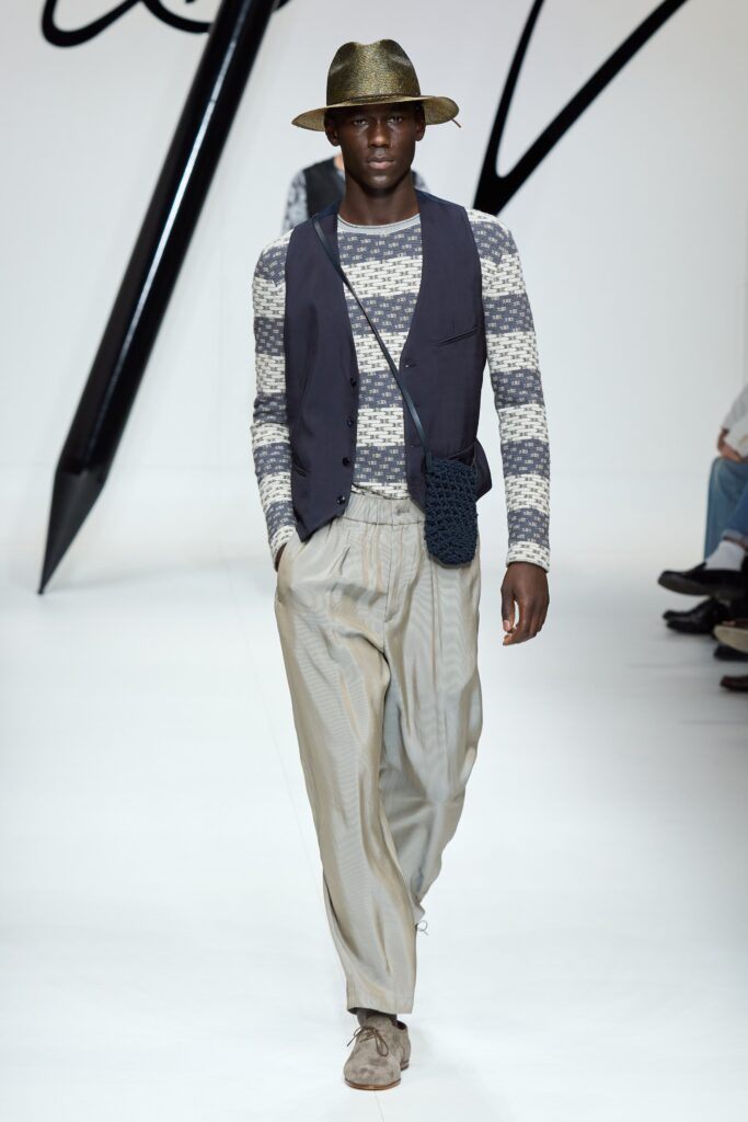 A relaxed gray cotton sleeveless vest paired with pleated beige pants.