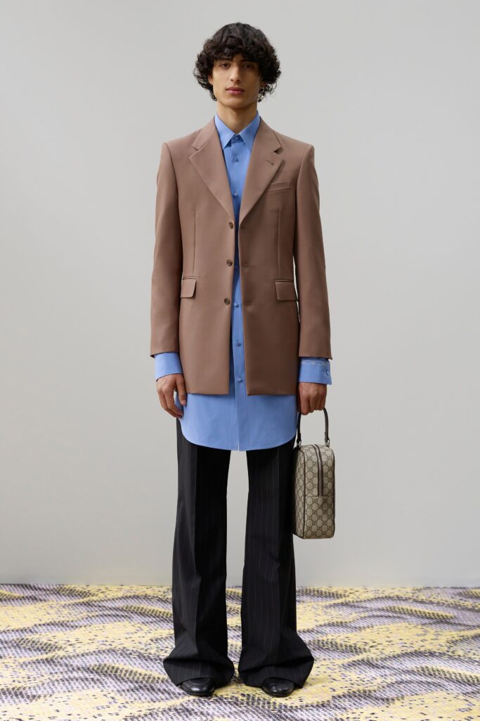 A relaxed brown blazer paired with a long-sleeve blue shirt featuring a buttoned design.
