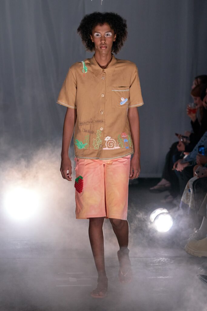 A relaxed beige cotton shirt with short sleeves and printed pink shorts.