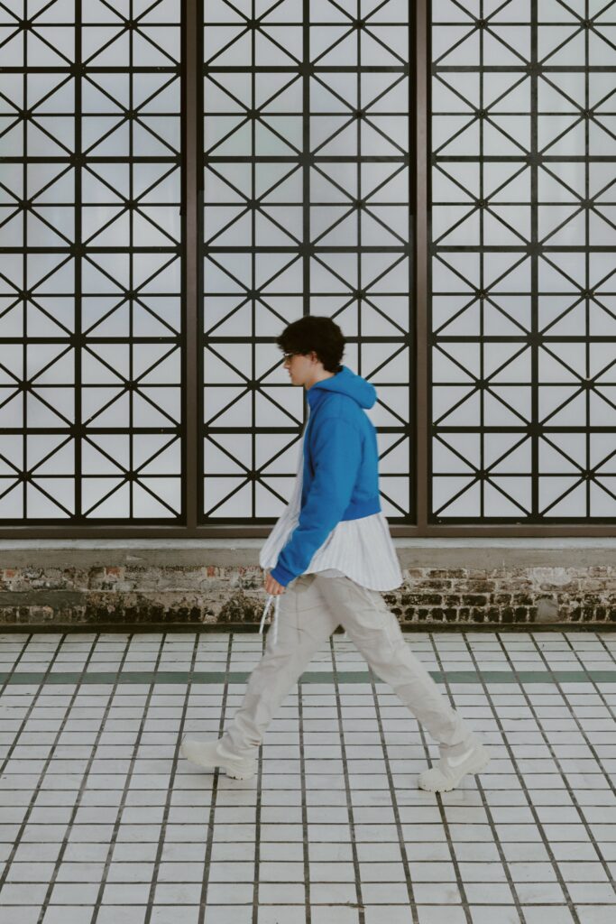 A relaxed blue hoodie layered over a white shirt with long sleeves.