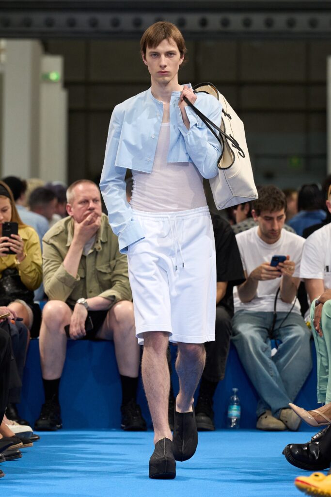 A fitted blue cotton short-sleeve jacket paired with white straight-leg shorts.